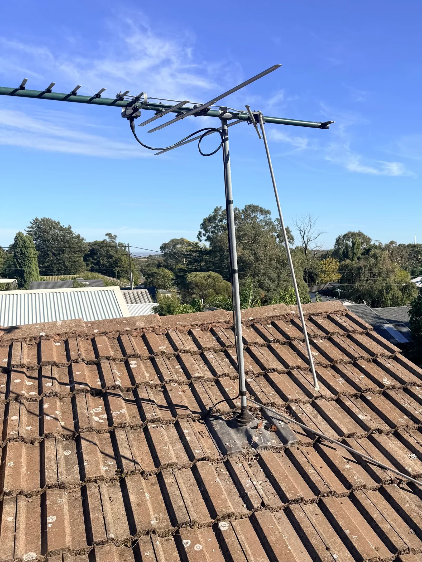 A storm-damaged TV antenna left bent and skewed on an Adelaide tile roof
