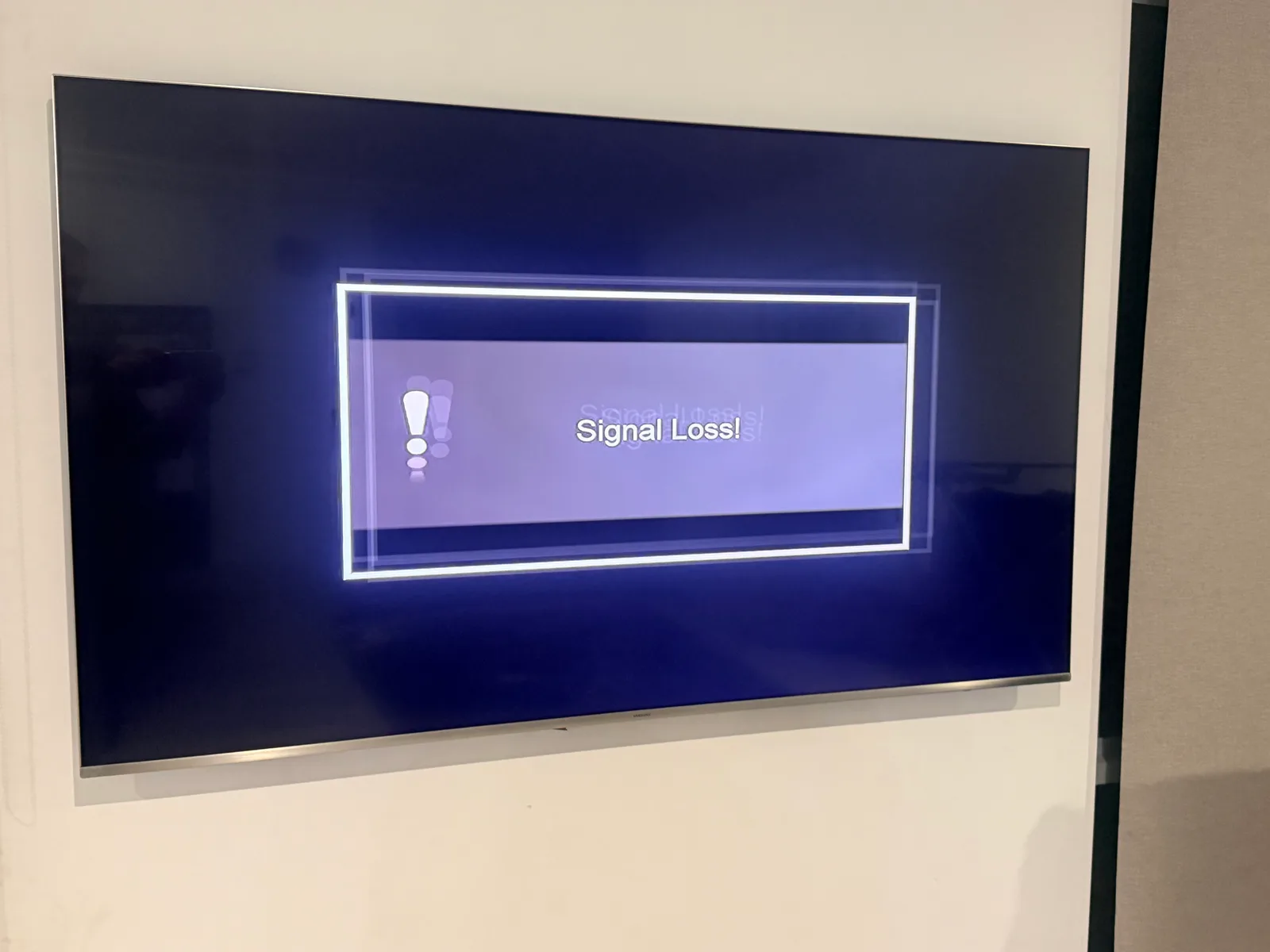 A wall-mounted TV showing a Signal Loss message when the reception drops out